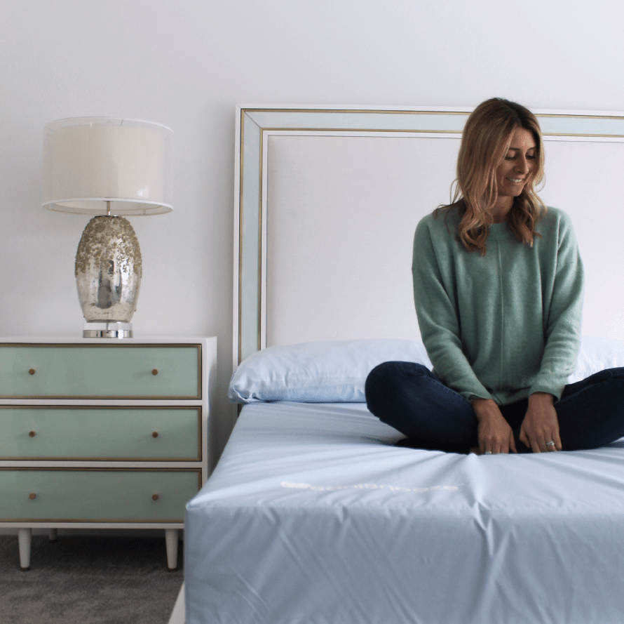 Model sitting comfortably on SaniSnooze Cloud Mattress