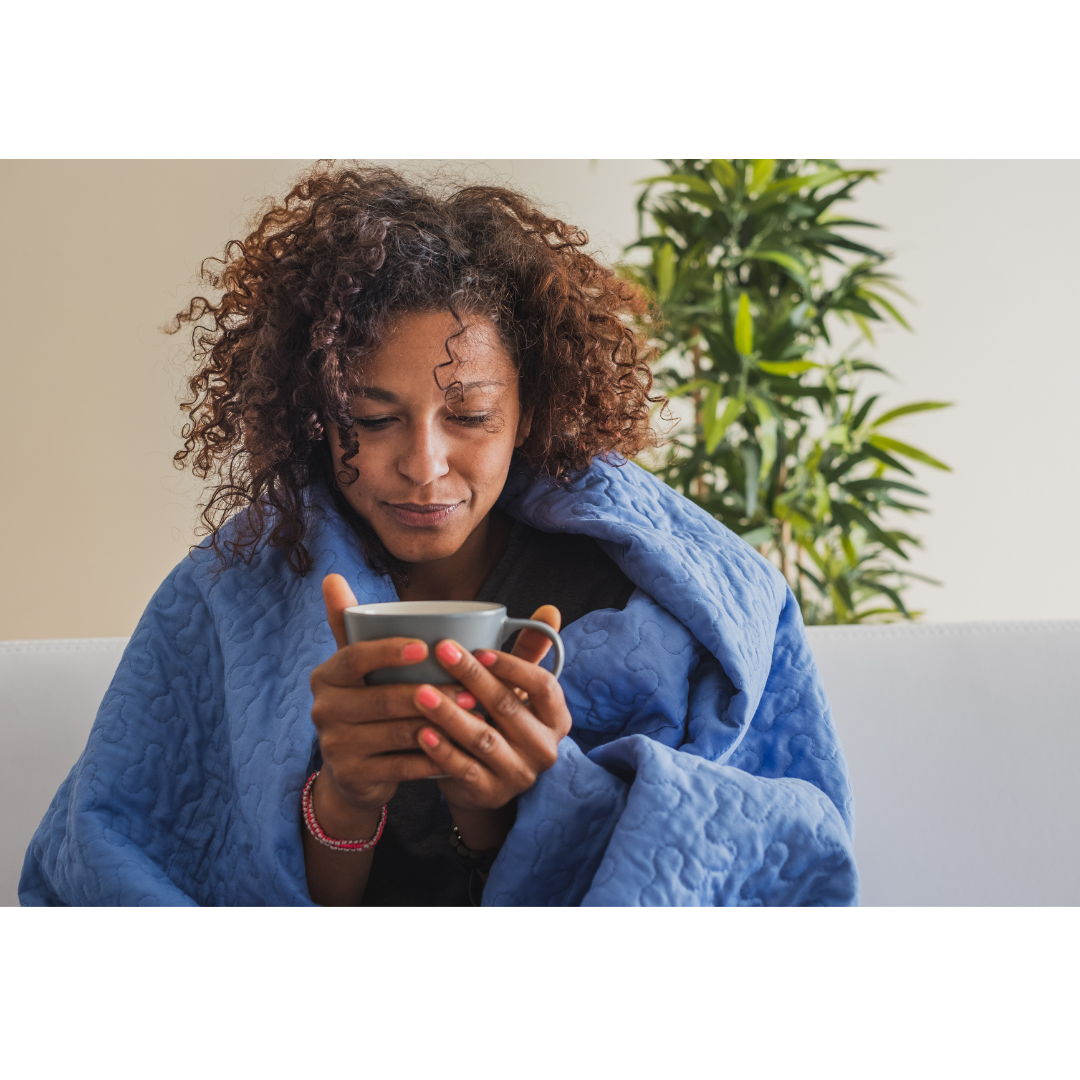 lady drinking coffee covered in blanket